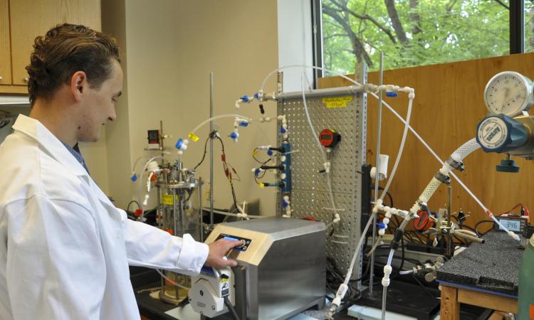 Environmental engineering student in a lab with testing equipment