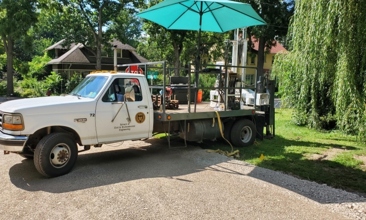 A truck with an umbrella and equipment on the flat bed.