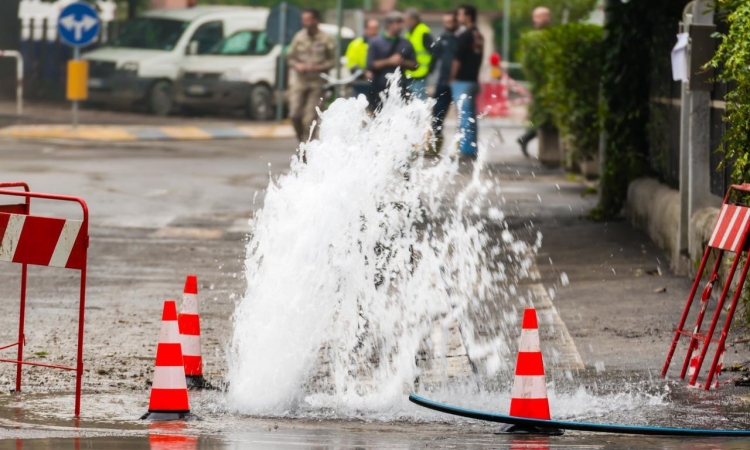 An image of a broken water main surrounded by orange cones