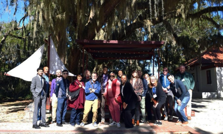 A group of people standing in front of a live oak tree