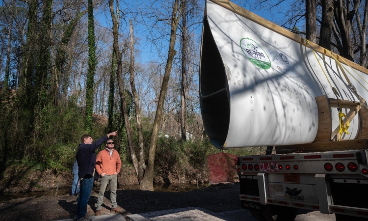 Two people looking at a decommissioned wind turbine blade