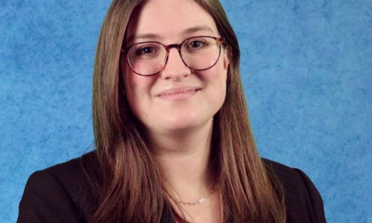 Portrait of Hannah Kessler wearing a black jacket and a beige top.
