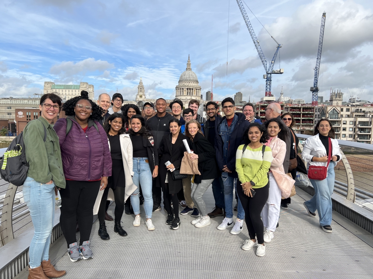 A group poses for a photo with a cathedral in the background