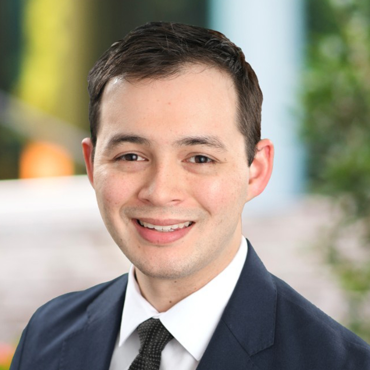 Portrait of Sam Dennard wearing a navy suit with a black tie