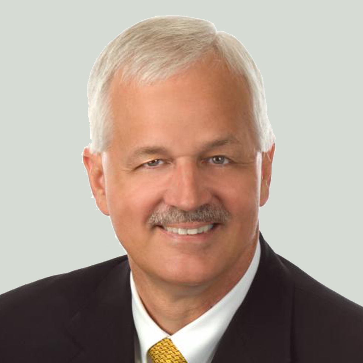 Portrait of Thomas Gambino in a dark suit and gold tie