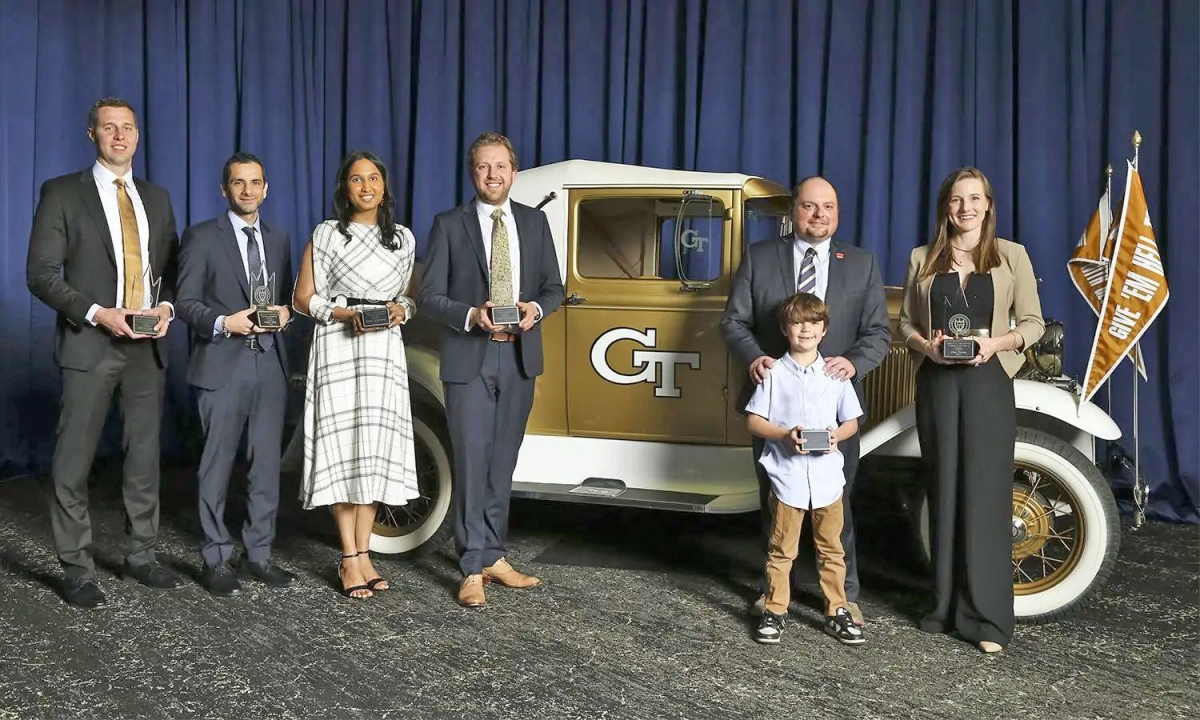 Group of Young Engineering Alumni honorees poses in front of the Ramblin‘ Wreck