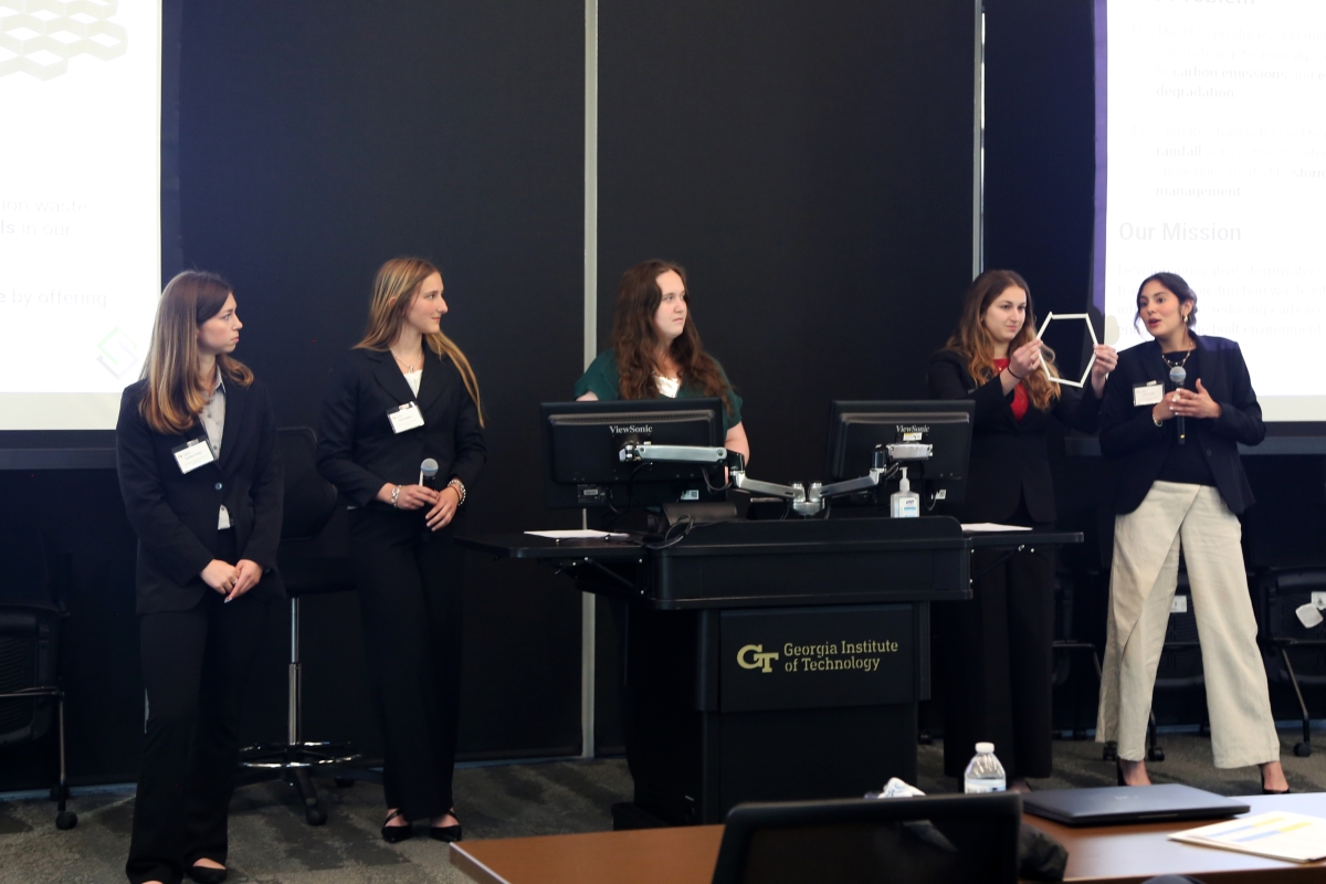 A group of five women demonstrate their product behind a lectern at the 2025 EIC.