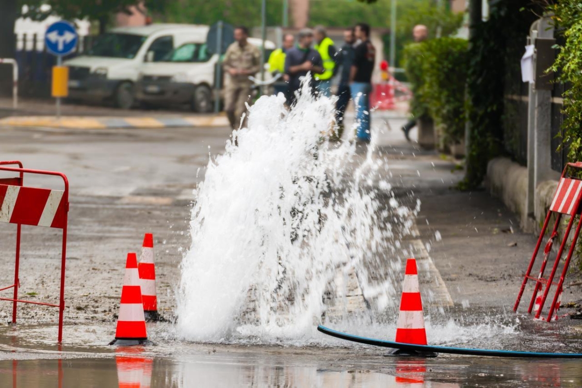 An image of a broken water main surrounded by orange cones