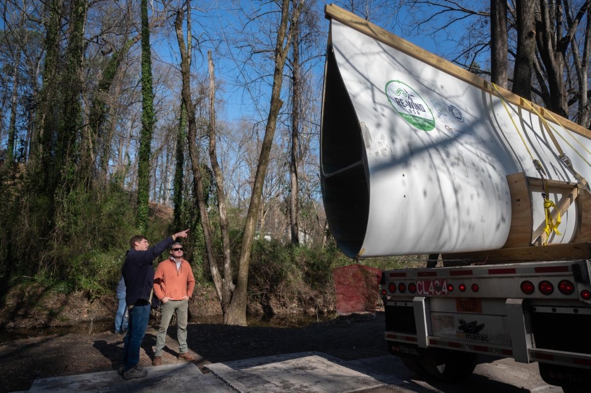 Two people looking at a decommissioned wind turbine blade