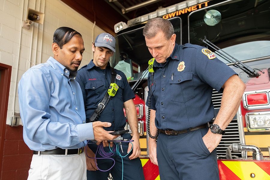 Angshuman Guin demonstrates how a cell phone tracks Gwinnett County Fire Department trucks and data about traffic to improve response times. Guin is working with Gwinnett on connected vehicle technology as part of the first round of Georgia Tech’s Georgia Smart Communities Challenge. (Photo: Allison Carter)