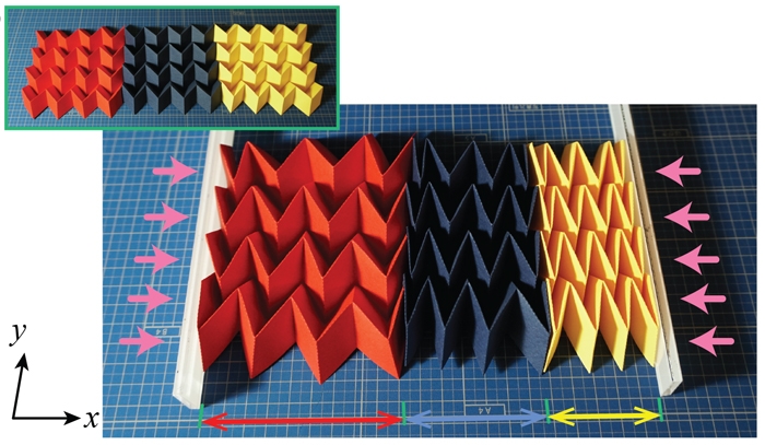 Red, navy blue and yellow paper folded into origami structures illustrate how the shapes change when pressure is applied.