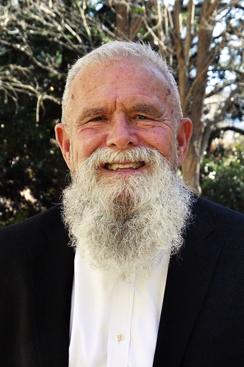 Portrait of Jon Drysdale in a dark blazer and a white dress shirt
