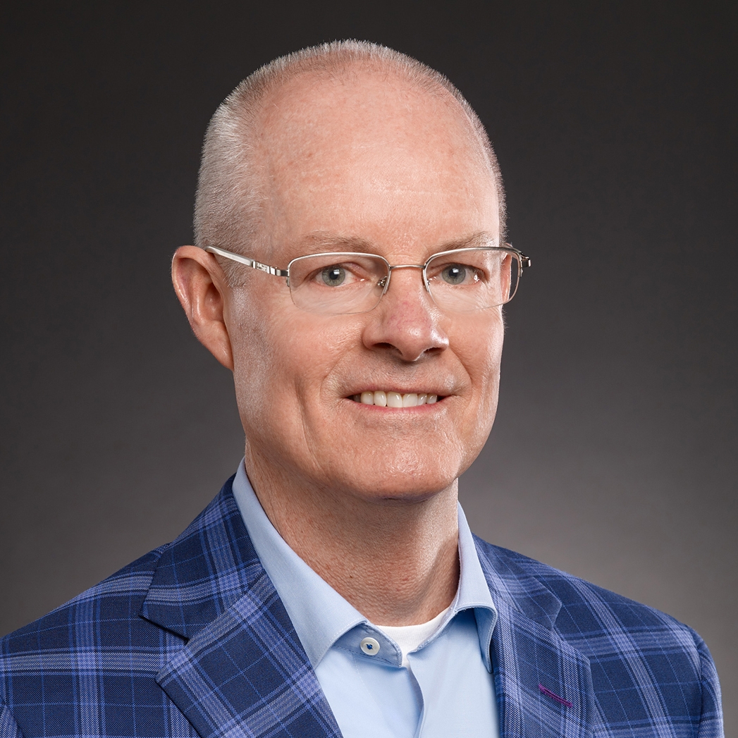 Cole Schnorf in a blue plaid jacket with a light blue shirt and a white t-shirt underneath