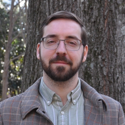 Portrait of Edvard Bruun wearing a green striped shirt and a light brown checked overcoat