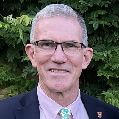 Portrait of Fred Meyer in a blue suit with a lavender shirt and a floral necktie
