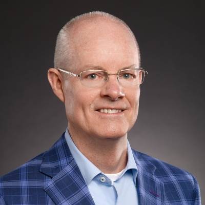 Cole Schnorf in a blue plaid jacket with a light blue shirt and a white t-shirt underneath