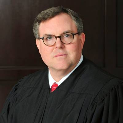 Jeff Bagley in a black robe with a white shirt and a red tie